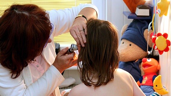 Eine Kinderärztin untersucht die Ohren eines Mädchens. © dpa 
