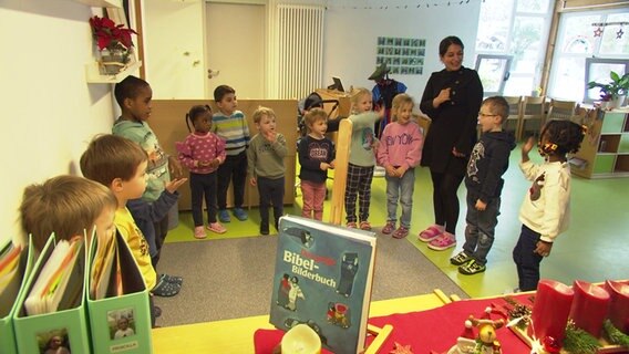 Eine Betreuerin steht zusammen mit Kindern in einem Gruppenraum in der Kita im Caritas-Familienzentrum Hannover-List. Eine Betreuerin steht zusammen mit Kindern in einem Gruppenraum in der Kita im Caritas-Familienzentrum Hannover-List. © NDR