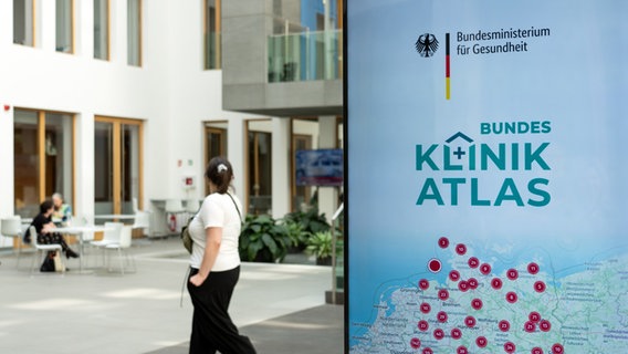 Eine Tafel vor einem Gebäude zeigt ein Werbeplakat für den Bundes-Klinik-Atlas mit einer Deutschlandkarte. © dpa Foto: Soeren Stache