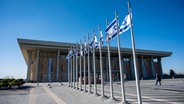 Israelische Fahnen wehen vor der Knesset, dem Einkammerparlament des Staates Israel. © Christophe Gateau/dpa 