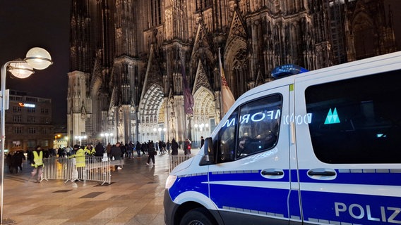 Köln: Ein Einsatzfahrzeug der Polizei steht vor dem Dom. © dpa Foto: Sascha Thelen