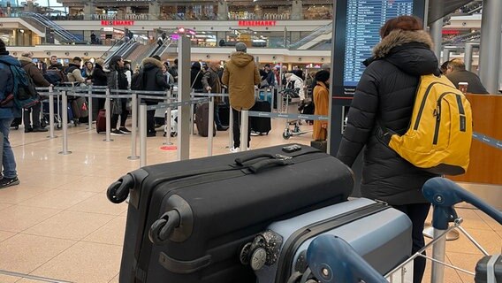 Wartende Fluggäste mit Gepäck © NDR Foto: Wiebke Neelsen