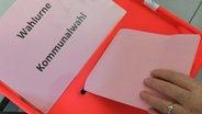 Eine Wählerin steckt ihren Stimmzettel bei einer Kommunalwahl in die Wahlurne. © dpa-Zentralbild Foto: Patrick Pleul