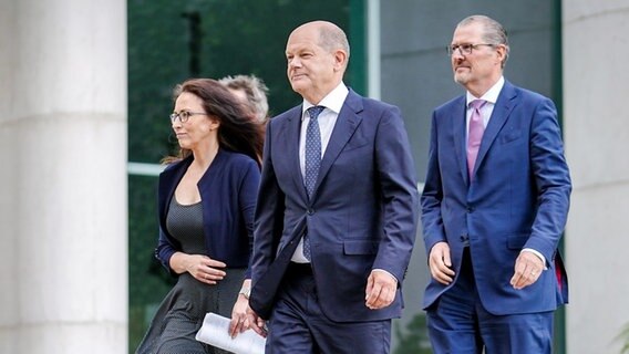 Bundeskanzler Olaf Scholz (M., SPD), Yasmin Fahimi, DGB-Chefin, und Rainer Dulger, Arbeitgeberpräsident, kommen im Bundeskanzleramt zur Pressekonferenz nach den Gesprächen zur sogenannten konzertierten Aktion gegen die Inflation in Deutschland. © picture alliance/dpa Foto: Kay Nietfeld