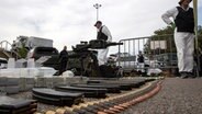 Kosovarische Polizisten zeigen beschlagnahmte Waffen und militärische Ausrüstung während des Polizeieinsatzes im Dorf Banjska. © Visar Kryeziu/AP/dpa 