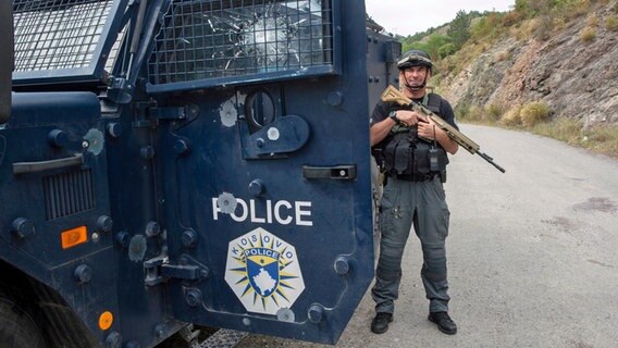 Ein Polizist aus dem Kosovo sichert das Gelände vor dem Banjska-Kloster. Nach den schweren Kämpfen zwischen serbischen Paramilitärs und kosovarischen Polizisten hatte die Staatsanwaltschaft in Pristina Untersuchungshaft für drei serbische Staatsbürger beantragt. © Visar Kryeziu/AP/dpa 