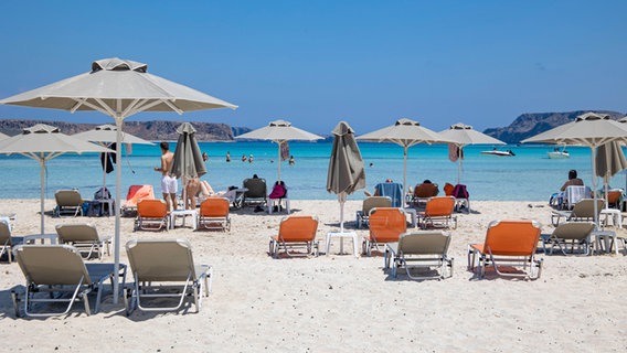 Menschen genießen die Sonne auf dem Balos Beach der griechischen Insel Kreta. © picture alliance / NurPhoto Foto: Nicolas Economou