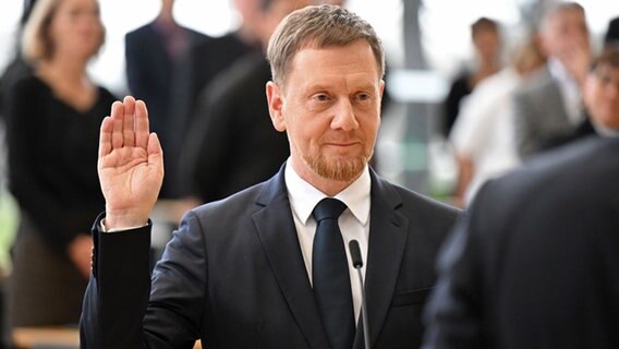 Michael Kretschmer (CDU) legt nach der Wahl zum Ministerpräsidenten von Sachsen im Plenarsaal im Sächsischen Landtag den Amtseid ab. © dpa-Bildfunk Foto: Robert Michael