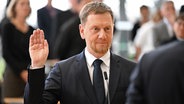Michael Kretschmer (CDU) legt nach der Wahl zum Ministerpräsidenten von Sachsen im Plenarsaal im Sächsischen Landtag den Amtseid ab. © dpa-Bildfunk Foto: Robert Michael