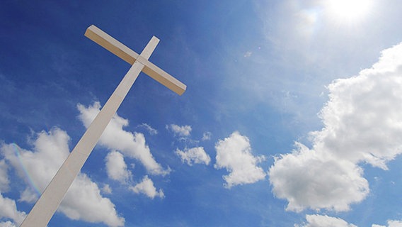 Ein Kreuz ragt in den Himmel © dpa Foto: Peter Kneffel