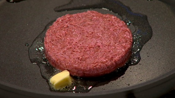 Eine rote Substanz wird mit einem gelblichen Stück fett in einer Pfanne gebraten. Eine rote Substanz wird mit einem gelblichen Stück fett in einer Pfanne gebraten. © NDR