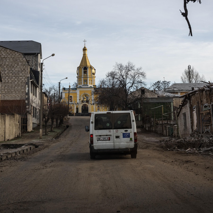 Ein Van mit evakuierten Einwohnern fährt durch zerstörte Straßen im ostukrainischen Kupiansk. © picture alliance / Anadolu Foto: Wolfgang Schwan