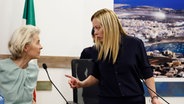 Ursula von der Leyen und Giorgia Meloni sprechen während einer gemeinsamen Pressekonferenz auf der Insel Lampedusa zueinander. © dpa-Bildfunk Foto: Cecilia Fabiano