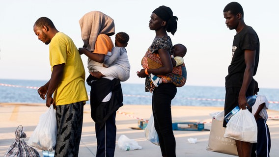 Menschen stehen auf der Insel Lampedusa in einer Reihe. © Cecilia Fabiano/LaPresse/AP/dpa 