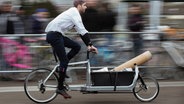 Ein Mann fährt auf einem Lastenfahrrad. © picture alliance/dpa Foto: Gregor Fischer