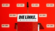 Schriftzug der Partei "Die Linke" auf einem Redner-Podium mit Mikrofon. © dpa picture alliance / Geisler-Fotopress Foto: Christoph Hardt
