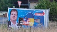 Wahlplakat der AfD mit Hannes Loth am Ortseingang von Ragun © Sebastian Willnow/dpa 