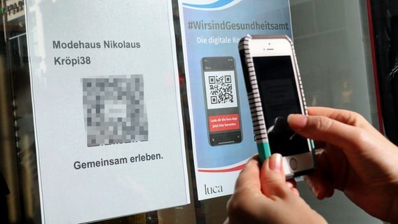 Eine Kundin scannt im Modehaus Nikolaus in Rostock den QR-Code der Luca-App zur Kontaktnachverfolgung. © dpa bildfunk Foto: Bernd Wüstneck