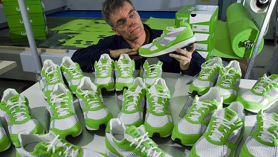 Geschäftsführer Ulf Lunge prüft einen Laufschuh in der Produktionshalle seiner Firma in Düssin (Kreis Ludwigslust). Geschäftsführer Ulf Lunge prüft einen Laufschuh in der Produktionshalle seiner Firma in Düssin (Kreis Ludwigslust). © dpa picture alliance Foto: Jens Büttner
