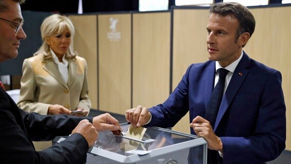 Emmanuel Macron, Präsident von Frankreich, und seine Frau Brigitte geben in einem Wahllokal ihre Stimmen in der ersten Runde der französischen Parlamentswahl ab. © dpa-Bildfunk 