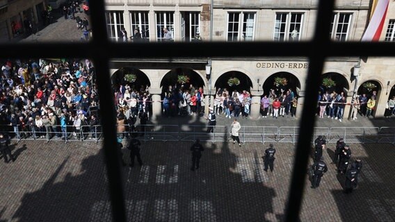 Schaulustige warten vor dem historischen Rathaus von Münster auf die Ankunft des französischen Präsidenten Macron. © dpa-POOL/dpa Foto: Rolf Vennenbernd