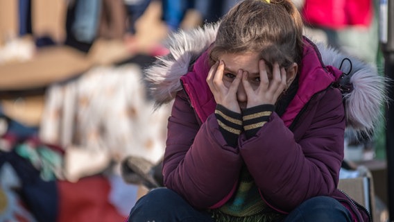 Ein Mädchen, das vor dem Krieg in der Ukraine geflohen ist, hält ihren Kopf als Zeichen der Erschöpfung in ihren Händen. © Hector Adolfo Quintanar Perez/ZUMA Press Wire/dpa 