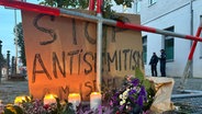 Kerzen stehen vor einem Schild mit der Aufschrift "Stop Antisemitism" bei einer Mahnwache nach dem versuchten Brandanschlag in der Nacht zum Mittwoch auf die Synagoge in der Berliner Brunnenstraße. © dpa Foto: Sven Kaeuler