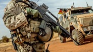 Ein Soldat der Bundeswehr steht mit einem Sturmgewehr vom Typ G36 am Flughafen nahe des Stützpunktes in Gao im Norden Malis. © dpa Foto:  Michael Kappeler