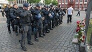 Minuten nach dem Bekanntwerden seines Todes trauern Polizisten auf dem Marktplatz in Mannheim um ihren getöteten Kollegen. Der Polizist war hier von einem Mann mit einem Messer niedergestochen worden. © Boris Roessler/dpa 