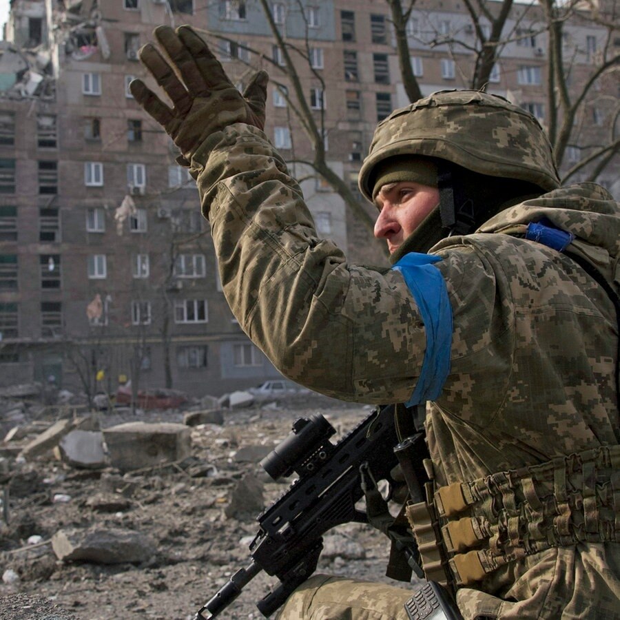Ein ukrainischer Soldat kniet inmitten von Trümmern in der Stadt Mariupol und gestikuliert. © AP/dpa Foto: Mstyslav Chernov
