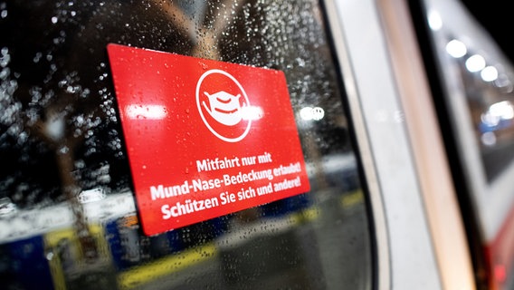 Ein Schild mit der Aufschrift "Mitfahrt nur mit Mund-Nase-Bedeckung erlaubt" an einem Zug © picture alliance/dpa | Hauke-Christian Dittrich 