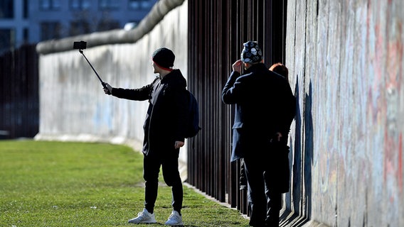 Touristen fotografieren sich auf dem Gelände der Gedenkstätte Berliner Mauer an der Bernauer Straße. © dpa bildfunk Foto: Britta Pedersen