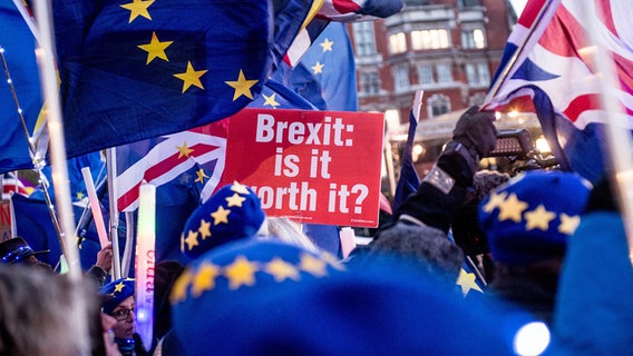 Bei einer Demonstration in London tragen Teilnehmerinnen und Teilnehmer vor dem Parlamentsgebäude Fahnen der EU und Großbritanniens sowie ein Transparent mit der Aufschrift: "Brexit: Is it worth it?". © dpa picture alliance/ZUMA Press Foto: OM1
