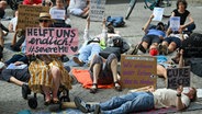 Demonstranten mit unter anderem dem Schild "Wir verlieren unser Leben, ohne zu sterben" haben sich vor dem Roten Rathaus für fünf Minuten zu einer Liegend-Demo auf den Boden gelegt. Die "Rollstuhldemo für die Inklusion und Sichtbarkeit von Menschen mit ME/CFS" wollte so auf die neuroimmunologische Krankheit Myalgische Enzephalomyelitis /Chronisches Fatigue Syndrom (ME/CFS) aufmerksam machen, die zu einem hohen Grad an der körperlichen Behinderung führen kann. (Foto vom 8.8.2024) © picture alliance/dpa | Soeren Stache 