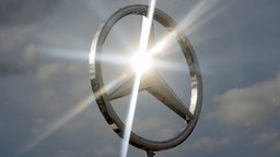 Ein strahlender Mercedes-Benz-Stern vor dem Himmel © dpa - Bildfunk Foto: Arno Burgi