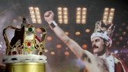 Freddie Mercurys charakteristische Krone vor einem Foto von Mercury © Kirsty Wigglesworth/AP/dpa 