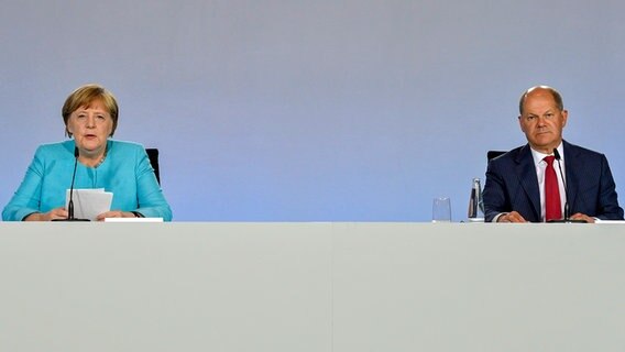 Bundeskanzlerin Angela Merkel (CDU) und Bundesfinanzminister Olaf Scholz (SPD) sitzen bei einer Pressekonferenz im Bundeskanzleramt. © dpa bildfunk/AFP/POOL Foto: John Macdougall
