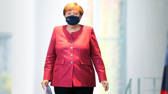 Kanzlerin Angela Merkel geht mit Mundschutz zu einem Pressetermin im Kanzleramt. © dpa-Bildfunk Foto: Axel Schmidt