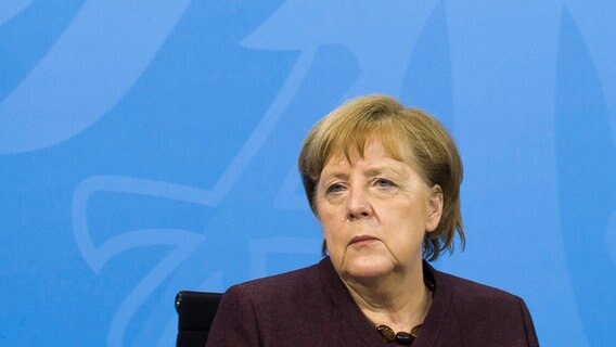 Angela Merkel sitzt bei einer Pressekonferenz auf einem Podium. © dpa-Bildfunk/AP Foto: Markus Schreiber