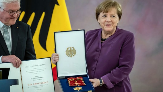 Angela Merkel, (CDU), ehemalige Bundeskanzlerin, bekommt von Bundespräsident Frank-Walter Steinmeier das Großkreuz des Verdienstordens der Bundesrepublik Deutschland in besonderer Ausführung im Schloss Bellevue verliehen. © Michael Kappeler/dpa 