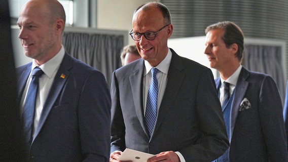 Der designierte Bundeskanzler Friedrich Merz (CDU, M.) gibt beim zweiten Wahlgang der Kanzlerwahl im Bundestag seinen Stimmzettel ab. © Michael Kappeler/dpa 