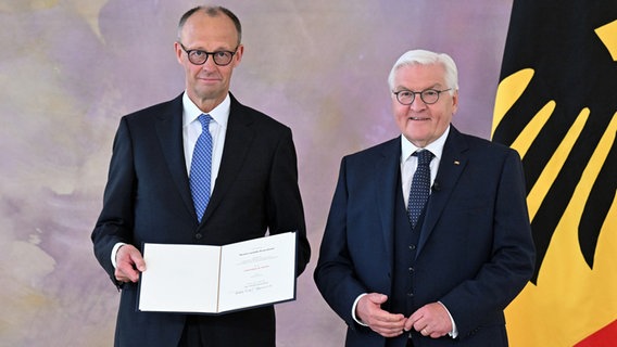 Bundespräsident Frank-Walter Steinmeier übergibt Bundeskanzler Friedrich Merz (CDU) im Schloss Bellevue die Ernennungsurkunde. © Bernd von Jutrczenka/dpa 