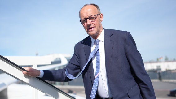 Friedrich Merz steigt in ein Flugzeug ein für seine erste Auslandsreise als Kanzler nach Paris und Warschau. © dpa Foto: Michael Kappeler