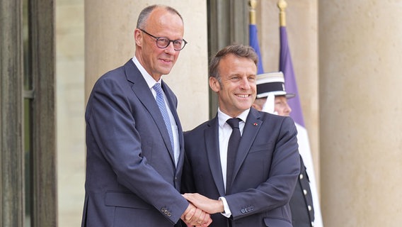 Der französische Präsident Emmanuel Macron (r) begrüßt Bundeskanzler Friedrich Merz (CDU) bei seinem Antrittsbesuch in Paris. © picture alliance/dpa | Michael Kappeler Foto: Michael Kappeler