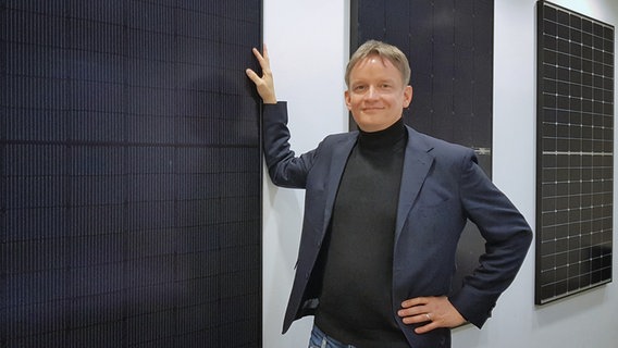 Gunter Erfurt steht vor einer Wand mit Solarmodulen der Firma Meyer Burger.  Foto: Klaas-Wilhelm Brandenburg
