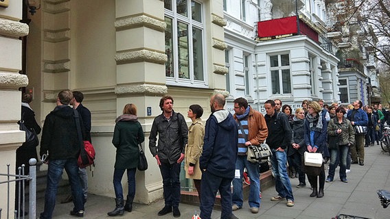 Wohnungssuchende stehen in einer Schlange auf der Straße vor einem Haus in Hamburg. © NDR Foto: Bettina Less