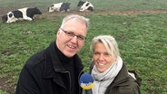 NDR Info Moderatorin Birgit Langhammer steht mit dem Öko-Milchbauern Hans Möller auf einer Kuhweide. © NDR Foto: Birgit Langhammer