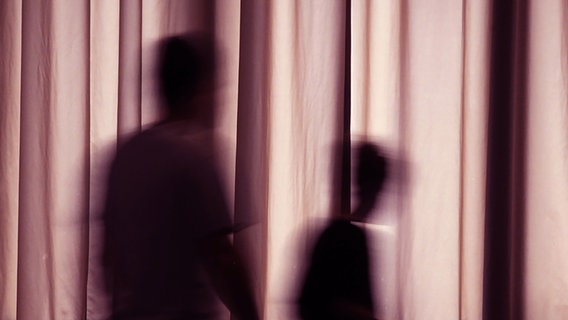Silhouette of an adult and a child behind a curtain.  © Photocase Photo: Schiffner