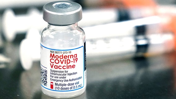 Ein Fläschchen des Moderna-Impfstoffes gegen das Coronavirus steht neben Spritzen. © dpa-Bildfunk 