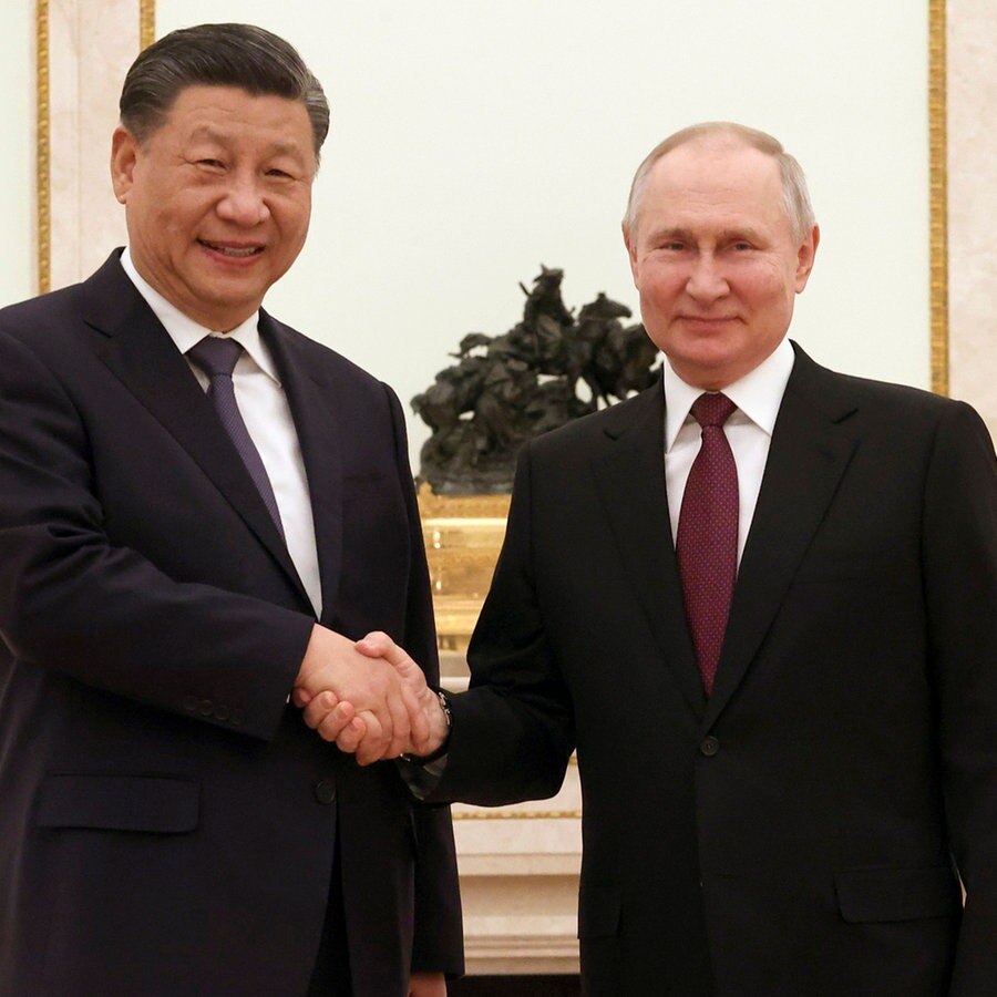 Wladimir Putin (r), Präsident von Russland, und Xi Jinping, Präsident von China, geben sich vor ihren Gesprächen im Kreml die Hand. © Sergei Karpukhin/Pool Sputnik Kremlin via AP/dpa 